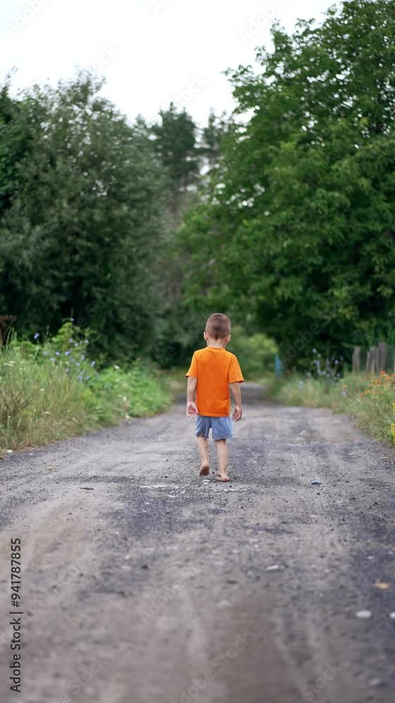 Little barefoot baby boy walking away outdoors. Kid stops, turns around and runs up to camera. Vertical video. Little barefoot baby boy walking away outdoors. Kid stops, turns around and runs up to camera. Vertical video.