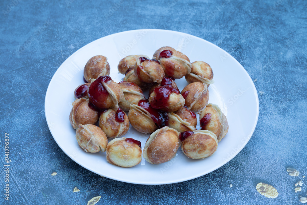A bowl of delicious walnut-shaped cookies made with boiled condensed milk in a white plate, with a walnut-like appearance made in a cast mold.