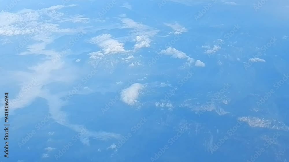 Aerial view from height of airplane flight of land with mountains with white Stratocumulus low level clouds. Topics: weather, meteorology, space, atmosphere, air travel Aerial view from height of airplane flight of land with mountains with white Stratocumulus low level clouds. Topics: weather, meteorology, space, atmosphere, air travel