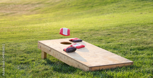 backyard fun with a game of cornhole, red bag in air 