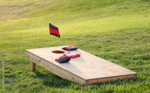wooden board on the grass, canvas bags of corn