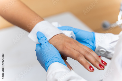 An orthopedic doctor is applying a bandage to the patient's wrist