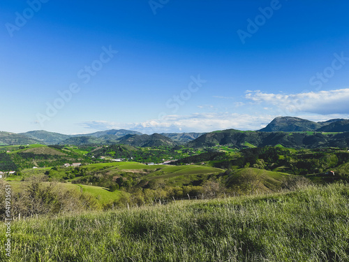 Hills covered with greenery and forests and rustic cottages among them. Landscape of northern Spain, Basque country.