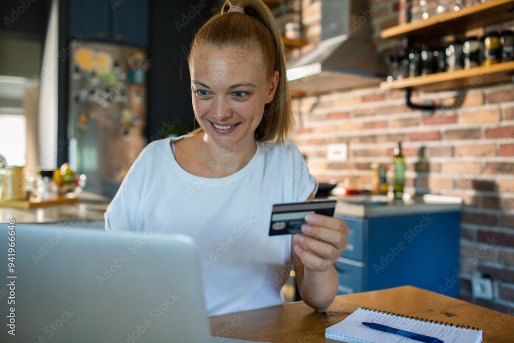 Young smiling woman shopping online with credit card at home Young smiling woman shopping online with credit card at home