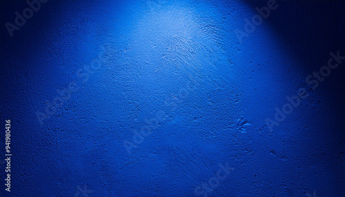 Blue textured wall with spotlight. Abstract decorative stucco backdrop.