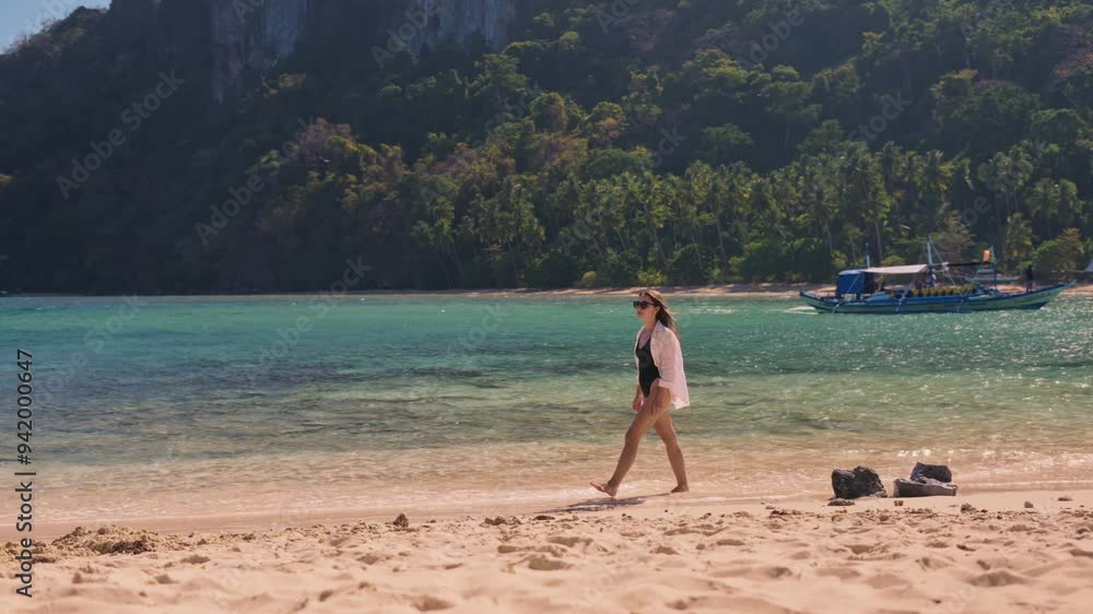 Slow motion of woman in white shirt walking along tropical beach remote island in Philippines. Travel video of woman relaxing and enjoying beach paradise during summer holiday Slow motion of woman in white shirt walking along tropical beach remote island in Philippines. Travel video of woman relaxing and enjoying beach paradise during summer holiday