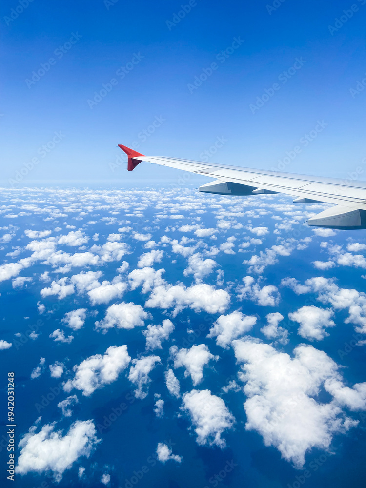 Fototapeta premium plane wing and aerial view of many fluffy clouds
