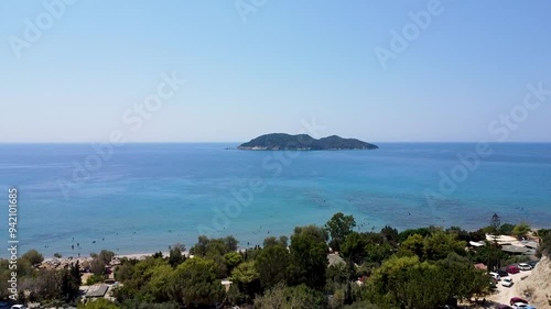  aerial footage of Fani Beach and the small Kalonisi Island in Zakynthos, Greece, highlighting the picturesque coastline, clear turquoise waters, and the serene beauty of the secluded island. photo