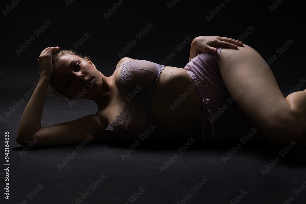 Low key portrait of beautiful female body on dark background Low key portrait of beautiful female body on dark background