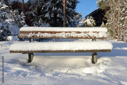 Park bench covered in snow. December nature. Järfälla, Stockholm, Sweden.