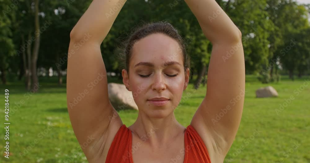 A woman does yoga in a city park. She is standing in the tree pose. Close-up of her face. Summer day A woman does yoga in a city park. She is standing in the tree pose. Close-up of her face. Summer day