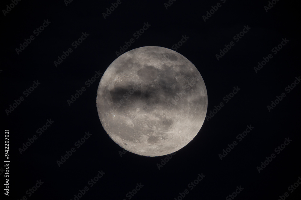 photograph of the full moon partially covered with clouds photograph of the full moon partially covered with clouds