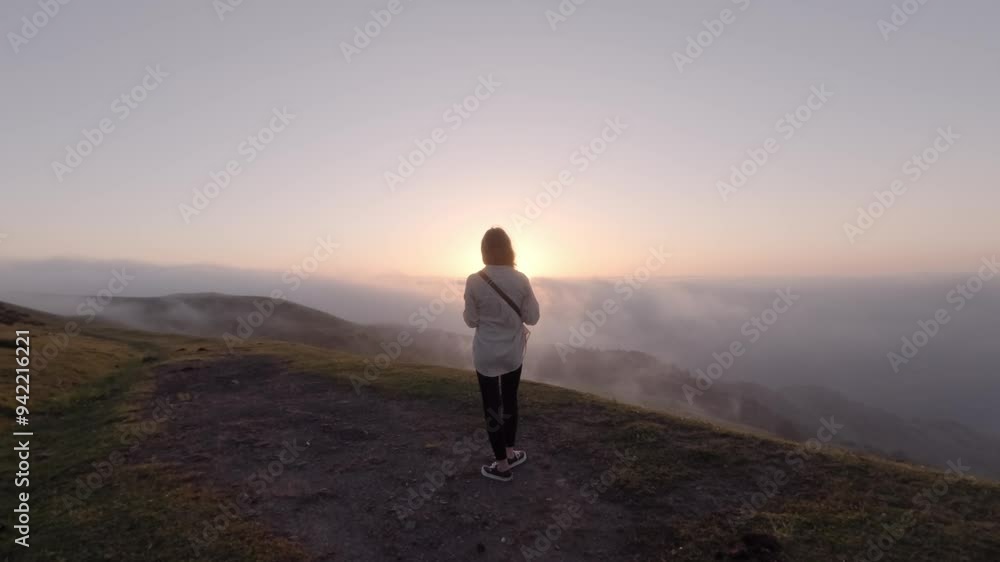 A woman taking photos from the beautiful sunset on a high mountain, Asturias, Spain. A woman taking photos from the beautiful sunset on a high mountain, Asturias, Spain.