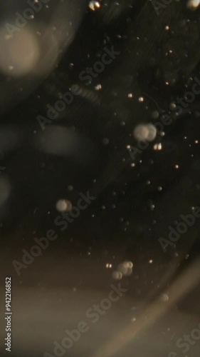 Vertical video of sparkling white air bubbles agaist black background, Extreme macro shot photo