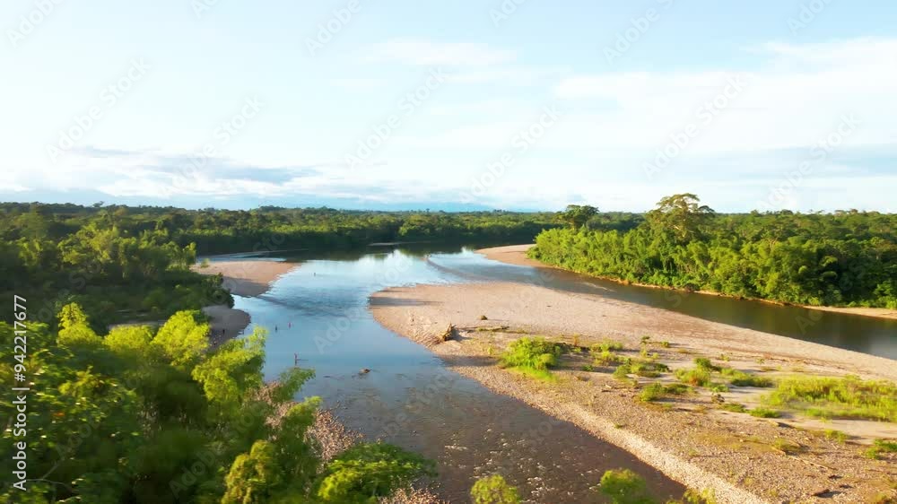 Drone rotates above Jungle river with sunlight revealing, rainforest environment Drone rotates above Jungle river with sunlight revealing, rainforest environment