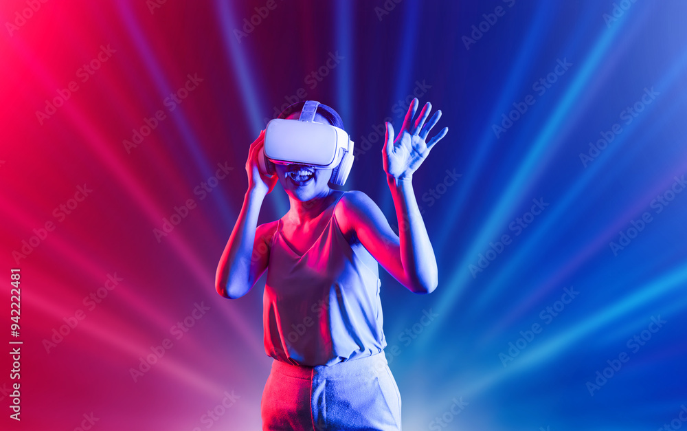 Smart female standing surrounded by neon light wearing VR headset connecting metaverse, future cyberspace community technology. Elegant woman enjoy dancing wavering body and sing song. Hallucination. Smart female standing surrounded by neon light wearing VR headset connecting metaverse, future cyberspace community technology. Elegant woman enjoy dancing wavering body and sing song. Hallucination.