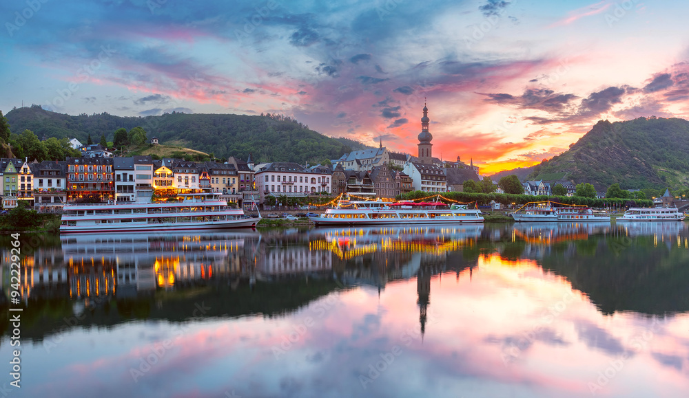 Sunset view of Cochem with Saint Martin Church, colorful buildings, and reflections, Germany Sunset view of Cochem with Saint Martin Church, colorful buildings, and reflections, Germany