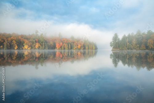 USA, New York, Adirondacks. Sun burns through fog on Rich Lake photo