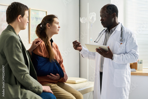 Φωτογραφία African American doctor explaining medical conditions to expectant mother and pa