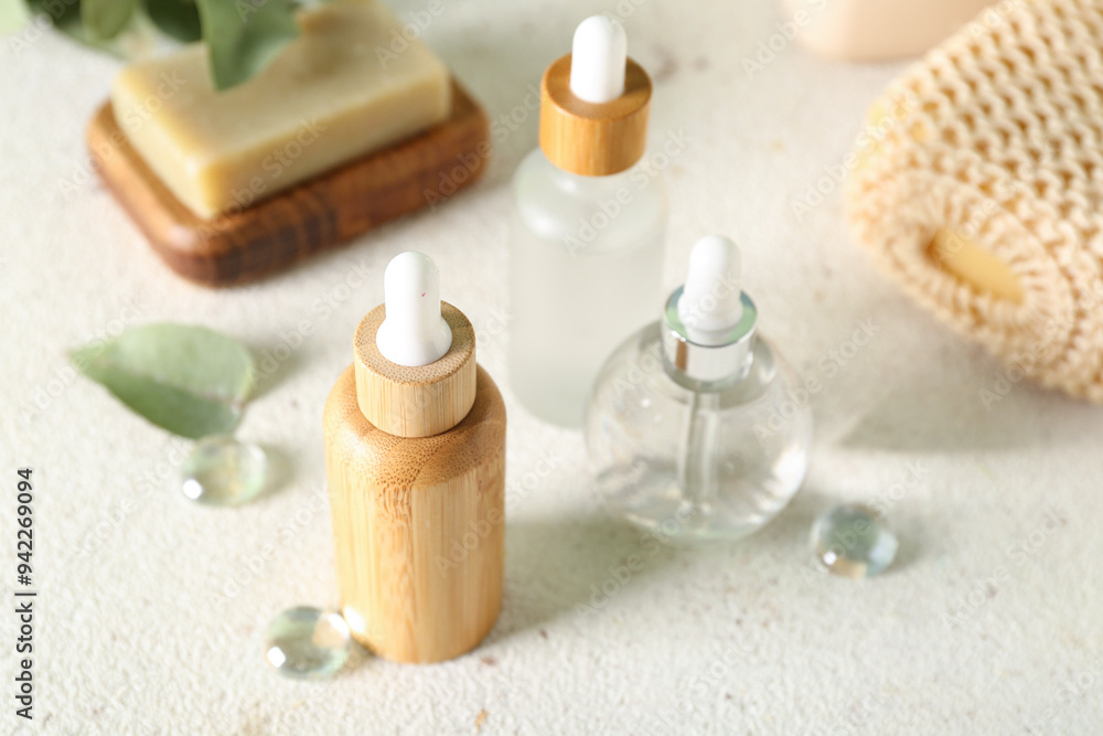 Cosmetic dropper bottles with soap and sponge on light background, closeup Cosmetic dropper bottles with soap and sponge on light background, closeup