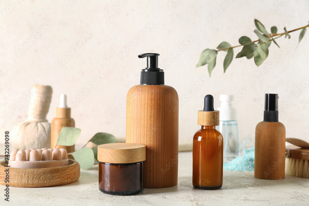 Bottles of cosmetic products, massage soap, herbal bag and cream on light background Bottles of cosmetic products, massage soap, herbal bag and cream on light background