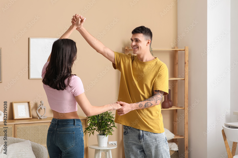 Beautiful young couple dancing in living room Beautiful young couple dancing in living room