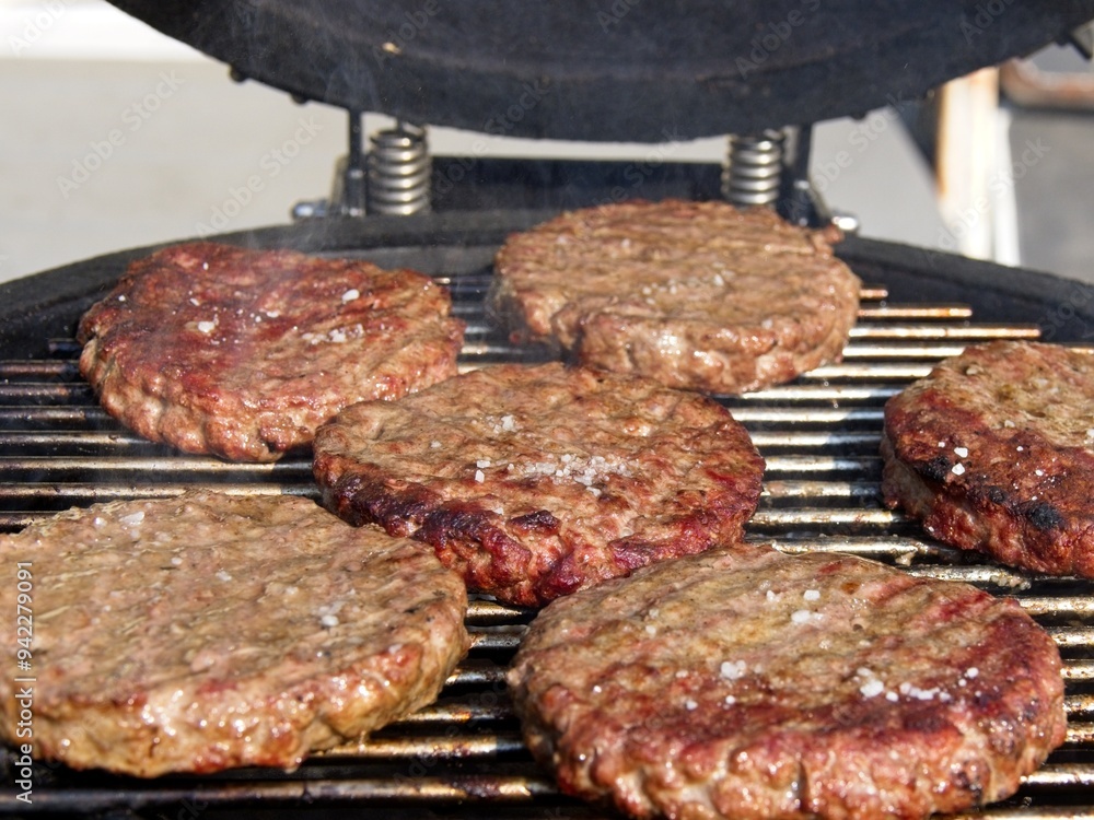 Beef burgers smoked and grilled on a barbeque over open flame Beef burgers smoked and grilled on a barbeque over open flame