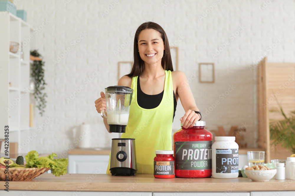 Sporty young happy woman making protein shake in blender at home Sporty young happy woman making protein shake in blender at home
