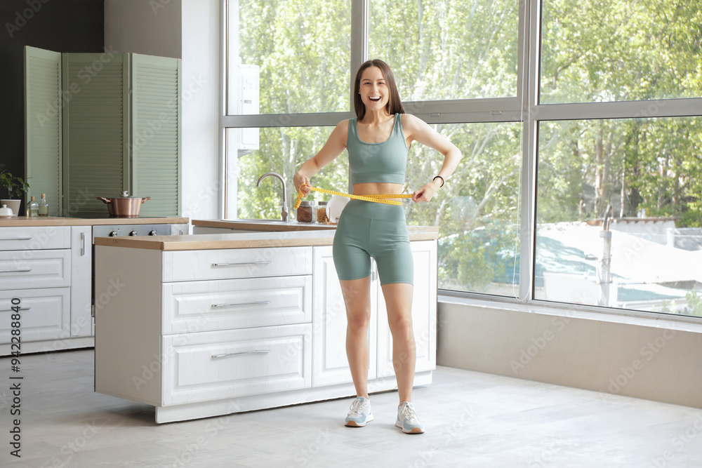 Beautiful young happy woman with measuring tape in kitchen at home. Weight loss concept Beautiful young happy woman with measuring tape in kitchen at home. Weight loss concept
