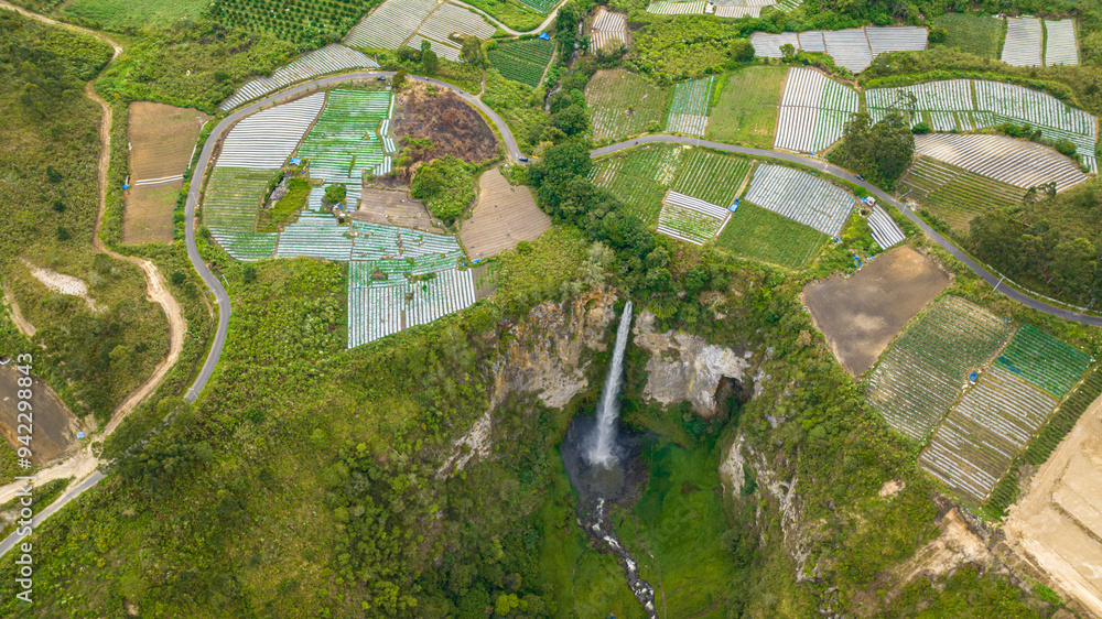 Fototapeta premium A beautiful waterfall among farmland. Sipiso Piso falls. Sumatra, Indonesia.