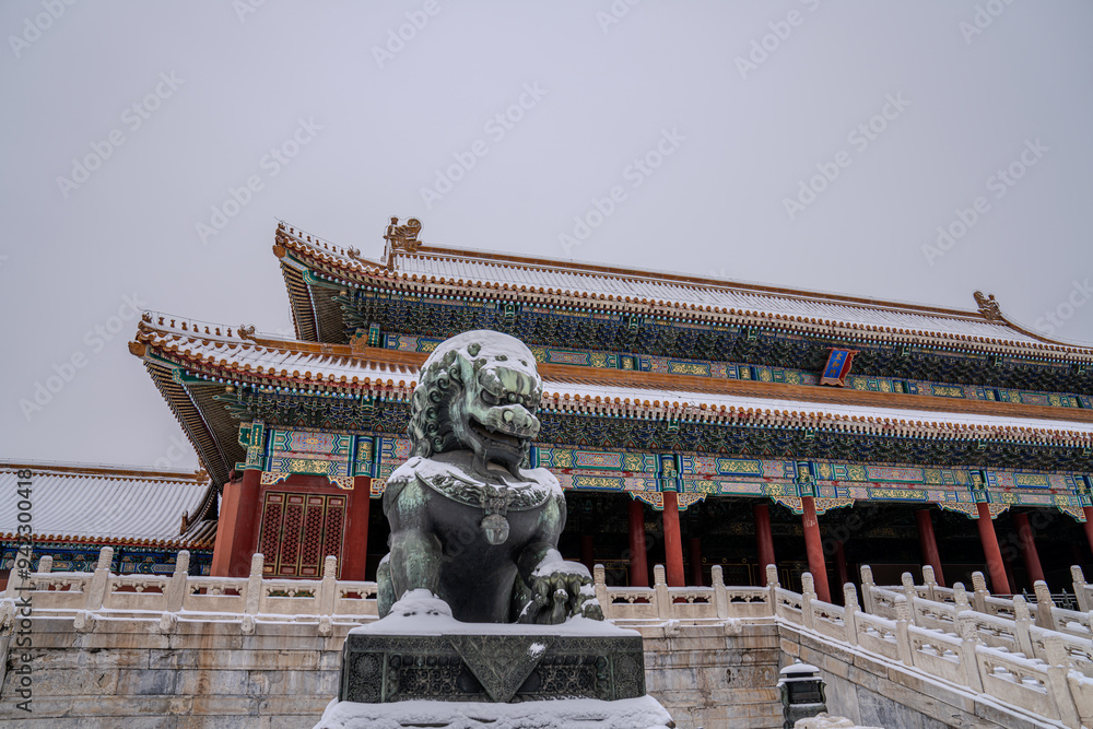Medium shot of stone lion in the Forbidden City, Beijing, China, covered in snow in cloudy weather with Taihegong in the background. Medium shot of stone lion in the Forbidden City, Beijing, China, covered in snow in cloudy weather with Taihegong in the background.