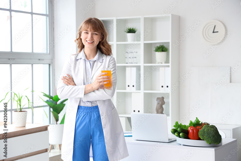 Female nutritionist with glass of juice in office Female nutritionist with glass of juice in office