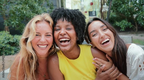 Group of young women smiling and looking at camera. Three multiracial teenage girls having fun together. Joyiful females laughing and gazing front. Feminine ladies bonding enjoying at their vacations