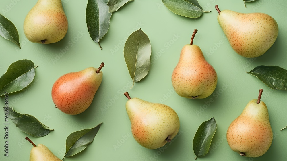 A flat lay of pears and leaves on a green background, showcasing fresh produce.