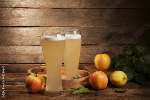 Glasses of fresh apple kvass and fruits on wooden background photo