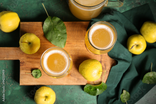 Glasses of fresh apple kvass and fruits on green background photo