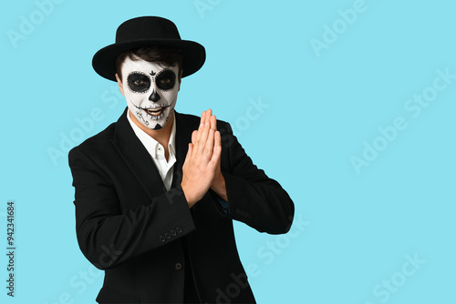 Young man dressed for Halloween on blue background photo