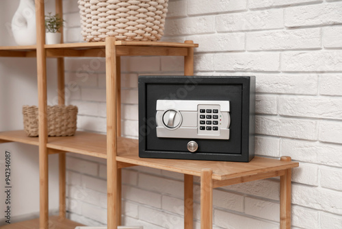Modern safe on shelf near w...