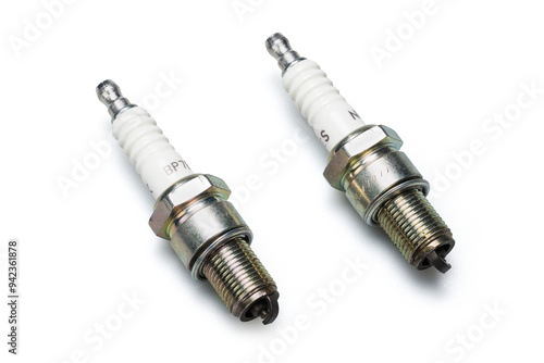 Studio photography of a spark plug with soft shadow isolated on a white background. New automotive spare parts for car internal combustion engines. Close-up automobile component. 