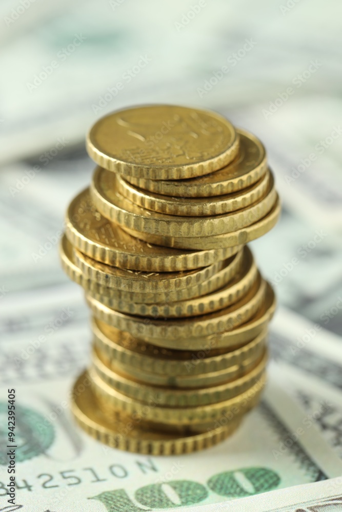 Stacked euro coins on dollar banknotes, closeup
