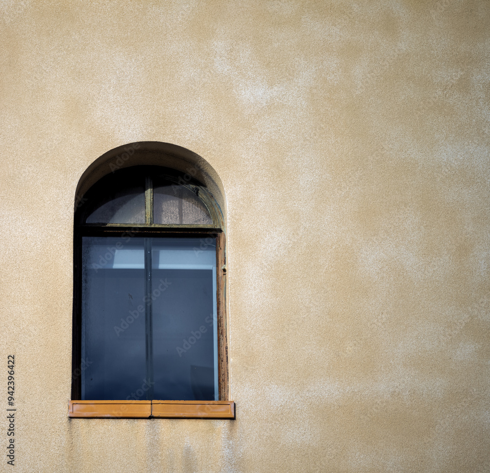Fototapeta premium Vintage Arched Window on a Faded Yellow Wall.
