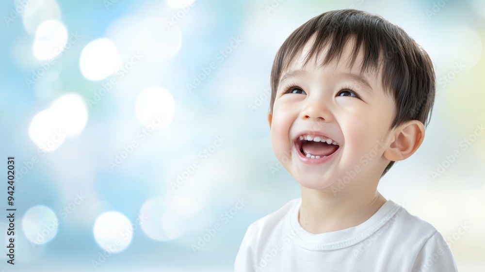 A young boy is smiling and laughing while looking up at the camera A young boy is smiling and laughing while looking up at the camera