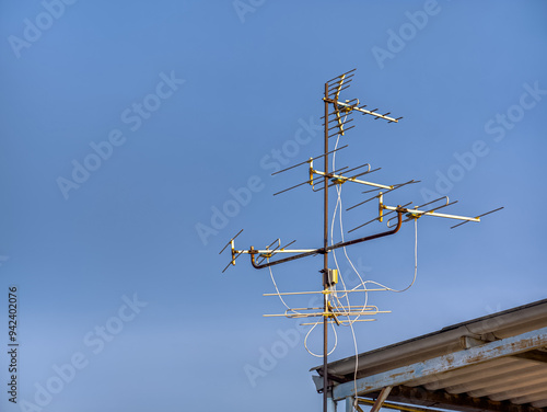 An old technology TV antenna in the evening sky on the roof.