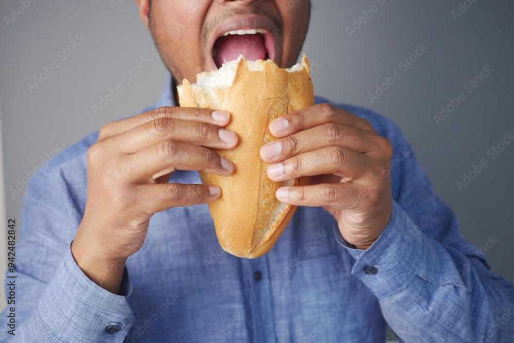 A Man Savoring and Enjoying a Delicious Sandwich that is Filled with Bold Flavor A Man Savoring and Enjoying a Delicious Sandwich that is Filled with Bold Flavor