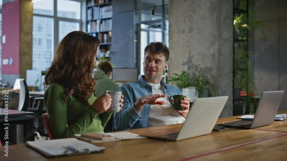 Two coworkers drinking tea sharing ideas in open space closeup. Happy colleagues Two coworkers drinking tea sharing ideas in open space closeup. Happy colleagues