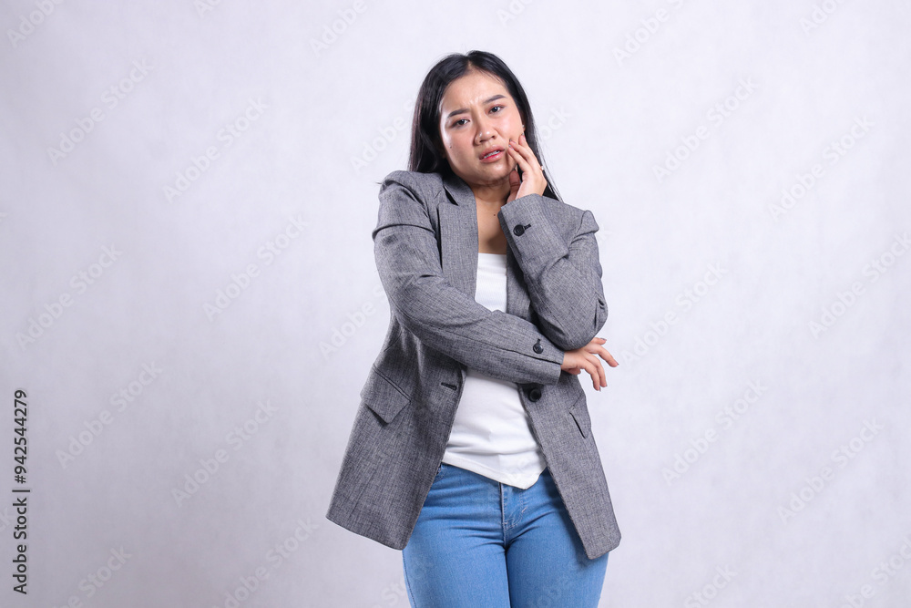 gesture beautiful young woman toothache hand hold cheek wearing grey suit and jeans standing isolated on white background. for health, treatment, commercial, prevention content gesture beautiful young woman toothache hand hold cheek wearing grey suit and jeans standing isolated on white background. for health, treatment, commercial, prevention content