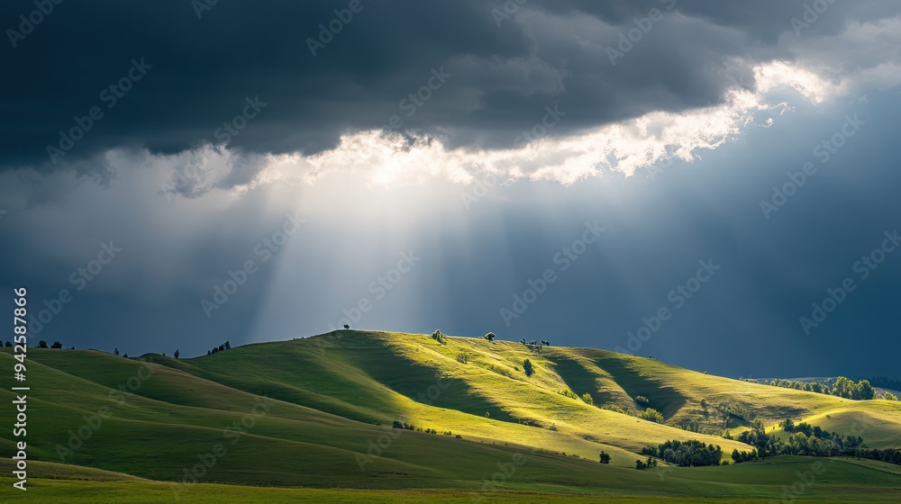 Fototapeta premium Sunbeams Through Storm Clouds Over Rolling Hills