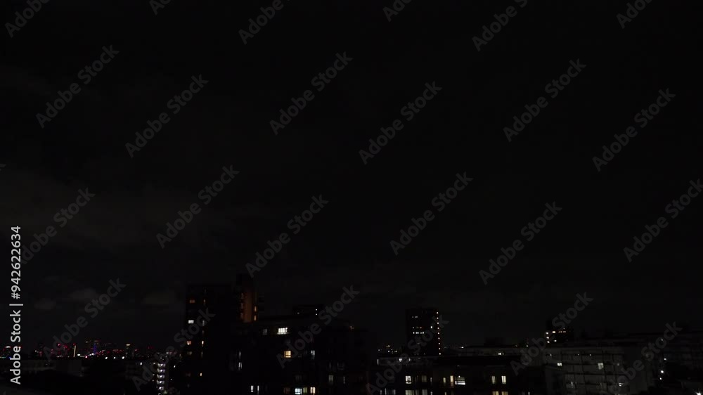 夏の夜の都市の住宅地と上空の雷と稲妻の様子 夏の夜の都市の住宅地と上空の雷と稲妻の様子