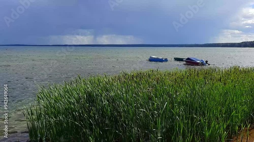 thunderstorm on the lake. summer, thunderstorm weather. reeds on the shore, boats on the water