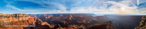 Grand canyon landscape with rugged terrain under a blue sky.